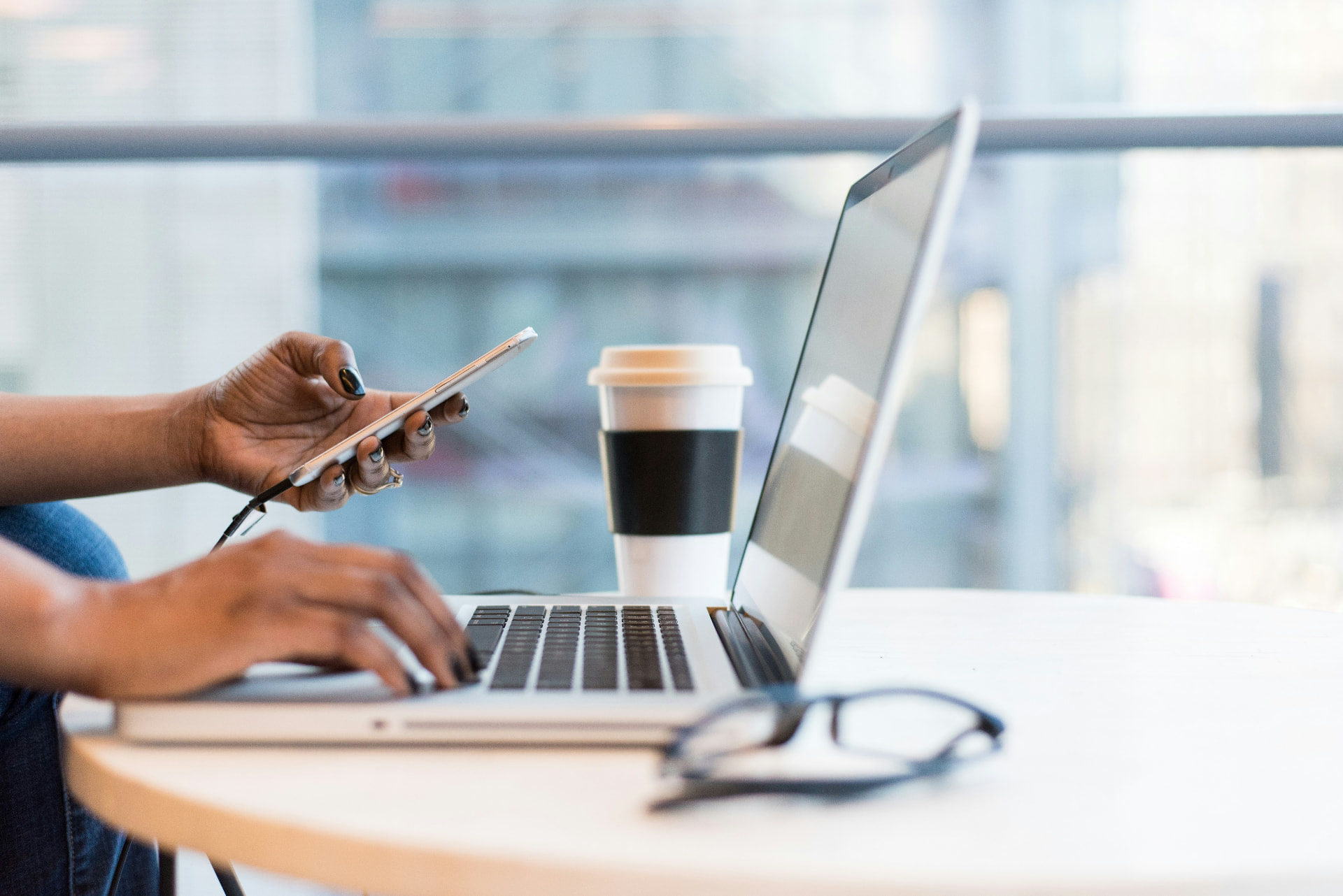 Consultant working on a laptop with a coffee cup and mobile phone