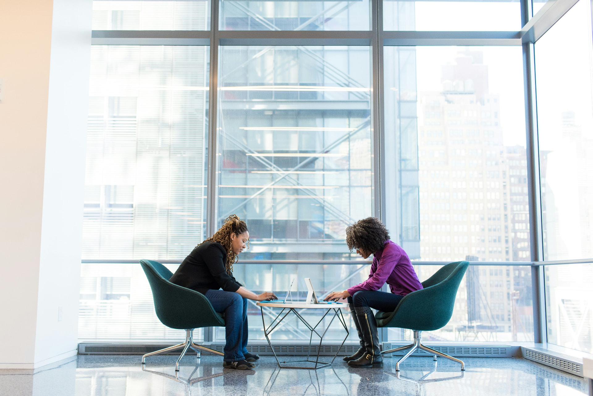 Two consultants reviewing strategy together on laptops